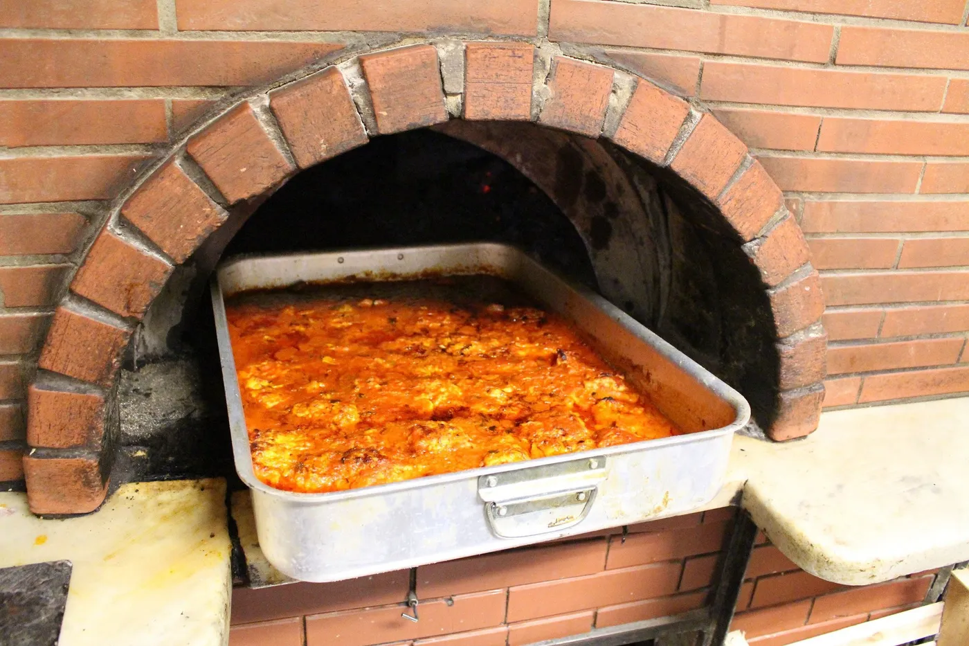 La teglia del baccalà alla livornese appena uscita dal forno a legna