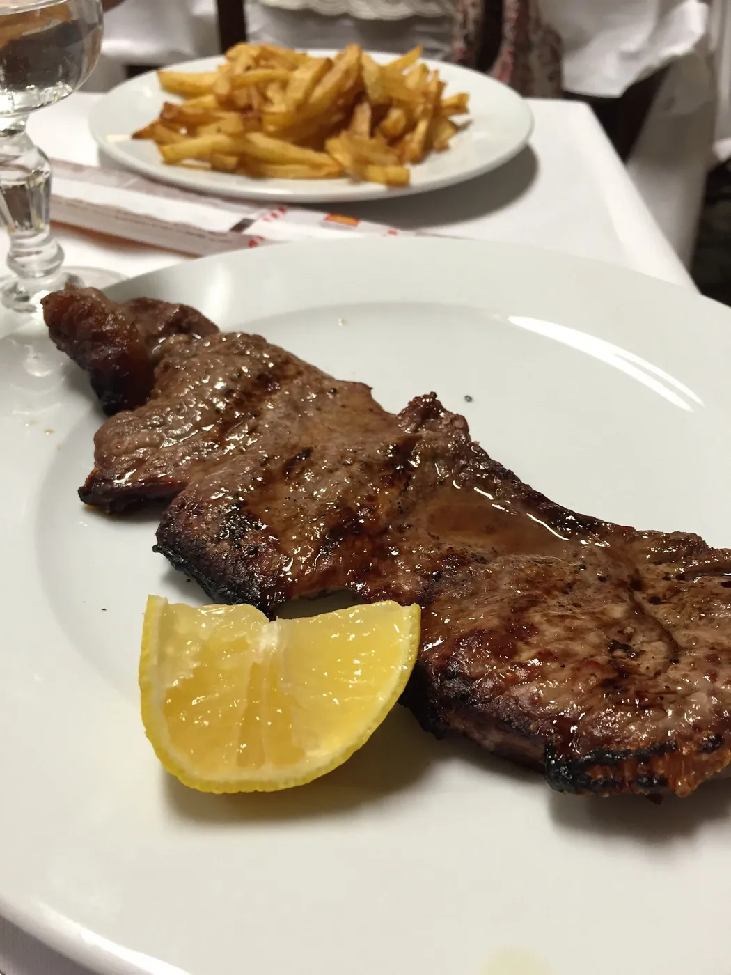 Carne alla griglia con le patate fritte e il limone